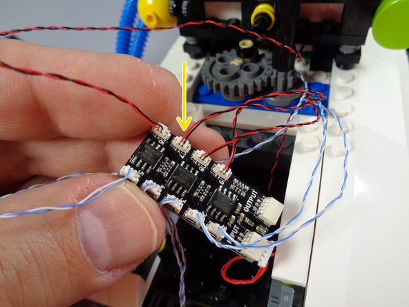 As shown by the green arrows in the first photo for this step, connect the two front blue lights (with blue/white wires) to plugs #1 and #2 on the BRANCH09X adapter board.