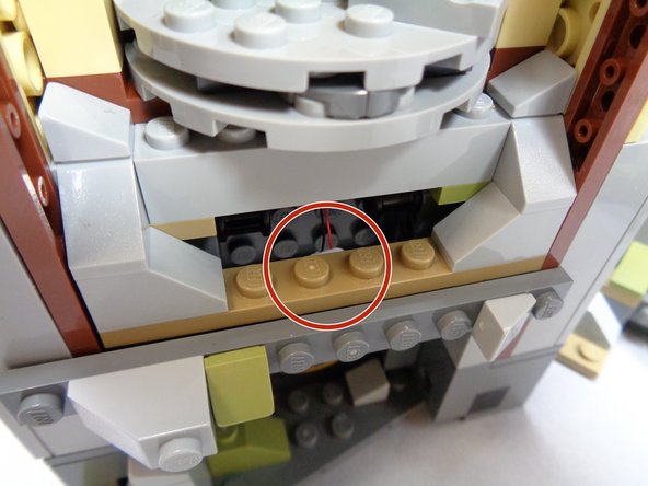 As shown by the red circle in the third photo, mount the green LED to the BACK side of the plate above the door at the base of the tower.