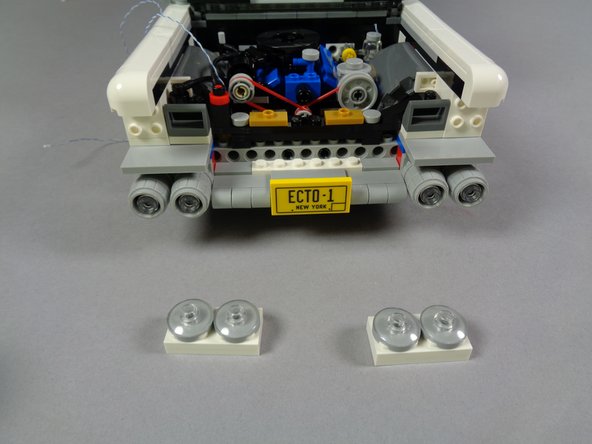 As shown in the first photo for this step, remove the two top headlight assemblies, including the two white 2x4 plates behind the headlights.