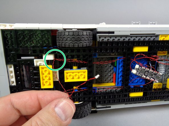 As shown by the green circle in the first photo and the two green rectangles in the second photo, pass the tail light wire through the Ecto-1 frame and into the same space as the BRANCH09X adapter.