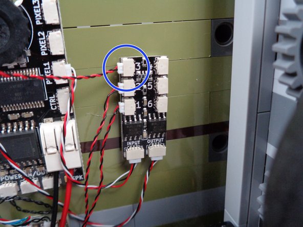 As shown by the two orange lines in the third photo for this step, pull the light wire for the green LED light so the wire passes between the studs of the green wall bricks.