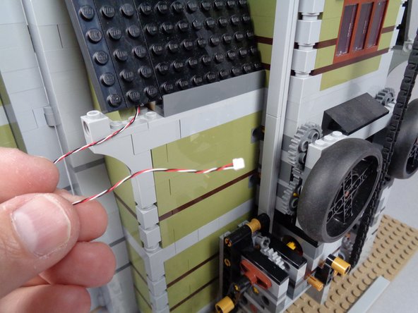 As shown in the first photo for this step, pull the long 3-wire cable all the way through the gap in the roof.