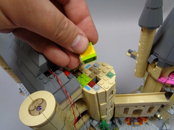 Continue carefully removing sections of the tower as shown.