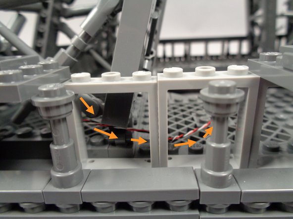 As shown by the orange arrows in the second photo for this step, route the control wire coming from the OUTPUT plug on the adapter board behind the window frames.