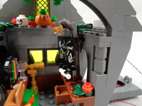 As shown in the second photo for this step, re-attach the blackboard to the desk.