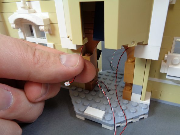 As shown by the first photo, pull the turret light wire down and out the front of the castle.