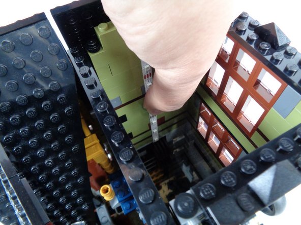 As shown in the photo for this step, press with  your finger or with a non-sharp tool to firmly attach the adhesive backing of the strip to the tower wall.