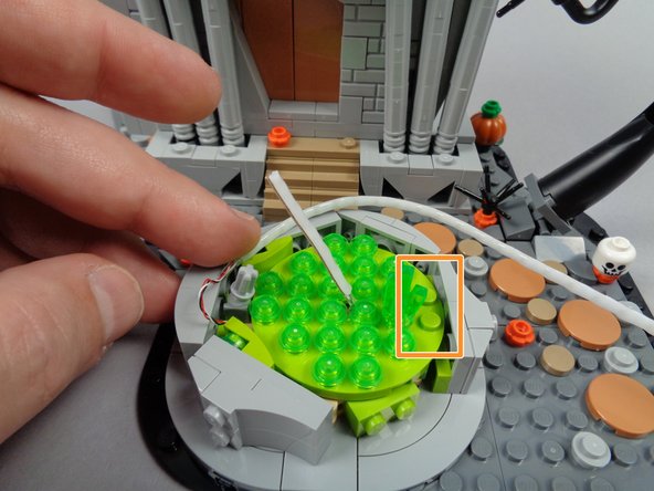 As shown in the first photo for this step, begin routing the long section of the light strip around the inside edge of the fountain, making sure the white part of the strip is facing toward the center of the fountain.