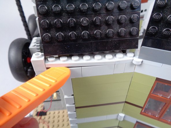 Remove the dark bluish gray panel between the roof and the top of the rear side wall as shown in the first photo.