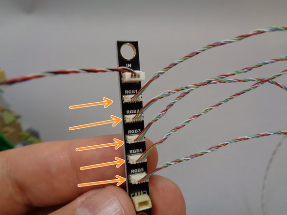 Take five of the color-changing spotlights from Bag 11 and connect them to the five plugs labeled &quot;RGB1&quot; through &quot;RGB5&quot; on the BRANCH17 adapter board as shown by the orange arrows in the first photo.