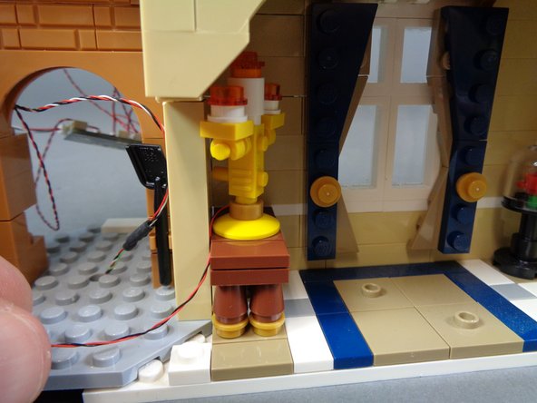 As shown in the second photo, re-attach the candelabra and its table, running the light wire down behind the table.