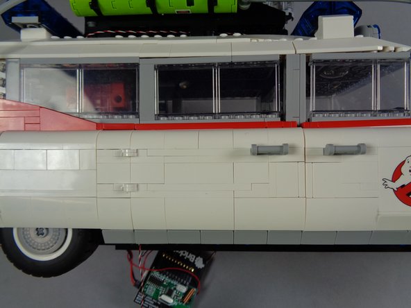 As shown in the second photo, close the side door to make sure it fully closes without pulling on the switch wire.  If the wire is too tight and prevents the door from fully closing, re-position the wire under the slope if needed to allow enough extra for the door to fully close.