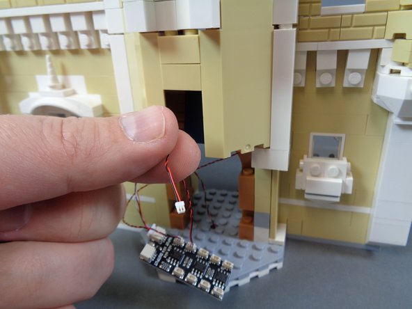 As shown in the second photo, pull the light wire out through the front of the castle.