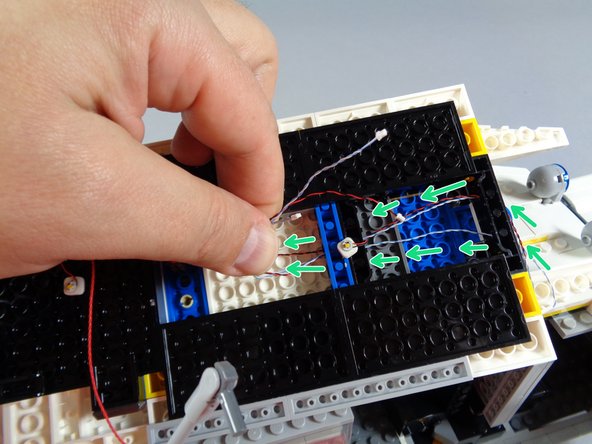 As shown in the first photo for this step, make sure the three light wires coming from the front roof section are straight, and also that they are not close to the hole in the center of the roof (where the steering axle goes).