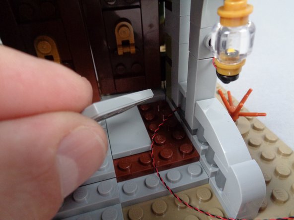 As shown in the first two photos for this step, remove the wheelchair ramp and the rightmost floor plate from the porch to make room to run the light wire.