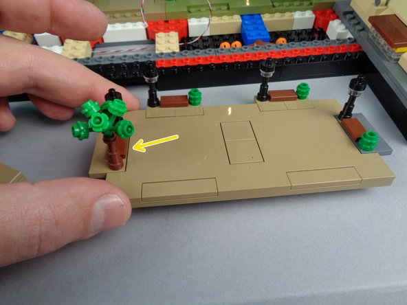 If one of the lamp posts from Panel 4F is attached to the small plate (as shown by the blue arrow in the first photo), remove it and attach it instead to Panel 4F as shown by the yellow arrow and also in the second photo.