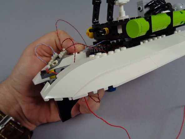 As shown in the first photo for this step, carefully re-attach the large white edge slope on top of the smaller slope.