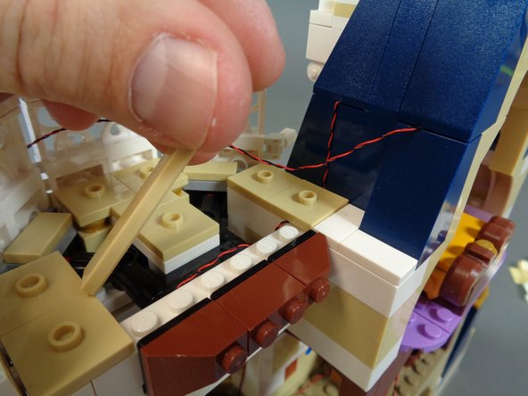 As shown in the first photo, remove the long tan LEGO tile.