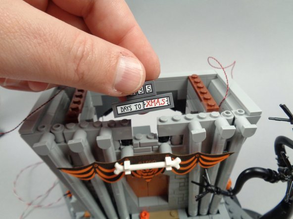 As shown in the third photo for this step, remove the center sign assembly from above the banner.