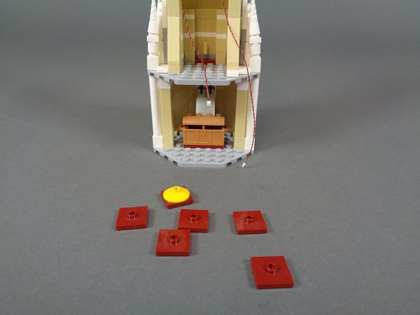 As shown in the first photo for this step, remove the six 2x2 dark red LEGO jumper plates from the floor of the mirror room.