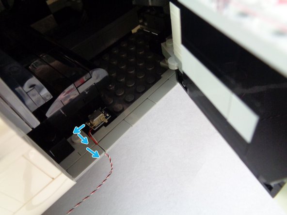 As shown by the blue arrows in the first photo for this step, bend the switch wire a bit so it forms an upside-down &quot;L&quot;.  This will allow the door to close without pulling the wire.