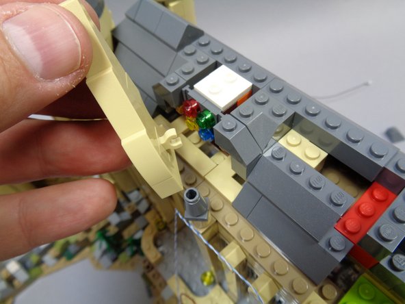 As shown in the first and second photos, remove the roof parts behind the stained glass window and also remove the front tan pieces framing the window.