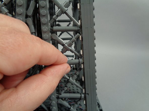 As shown by the yellow arrow in the first photo for this step, press down to clip both legs back into place.