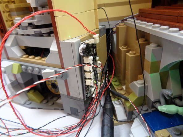 Bag 1 includes several Velcro dots or squares.  You can use these if desired to attach the TRUNK08 master controller to the inside base of the main tower if desired.