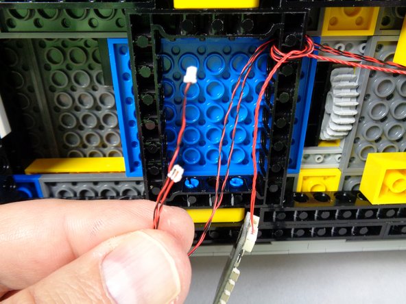 As shown in the first photo for this step, find the two hood strobe light wires, and connect one of these to plug #1 on the BRANCH09X adapter as shown by the green arrow in the second photo.