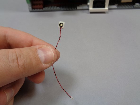 As shown in the first photo, attach a small sticky square to the back of the green Pico LED light with 3&quot; (7.6cm) wire from the bag of green LEDs.