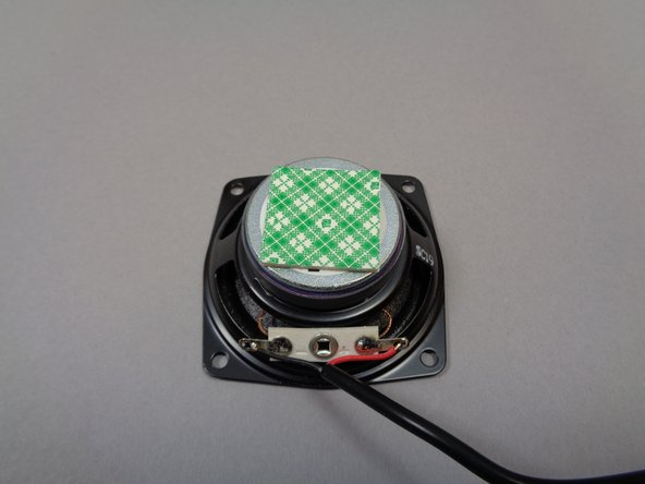 Inside Bag 7, there should be two squares of double-stick tape (see the second photo).  You will use these to mount the speaker inside the base of the castle.