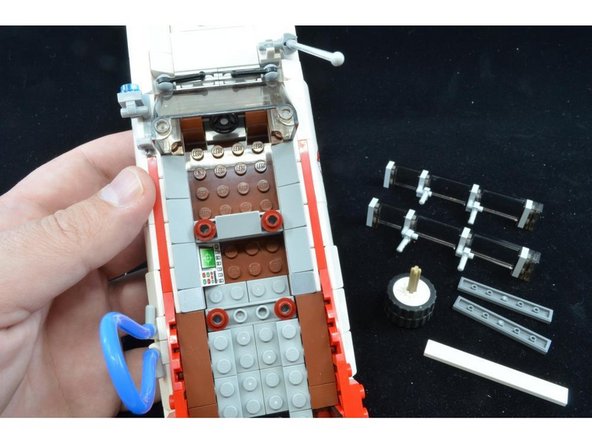 As shown in the second photo, remove the two dark gray tiles from the center back section, and also remove the two side window assemblies.