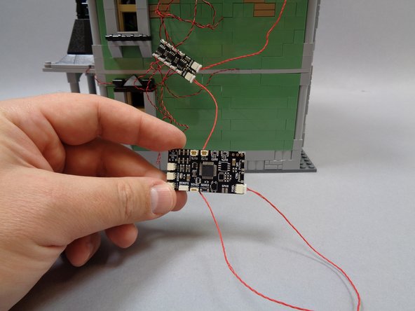 As shown by the red arrow in the second photo, connect the other end of the red control wire to the plug on the TRUNK08 master controller labeled &quot;PIXEL&quot;.