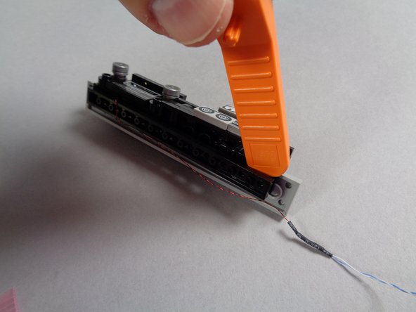 As shown in the first photo for this step, take a brick separator and gently loosen the long black plate under the dashboard, on the side opposite the speedometer.