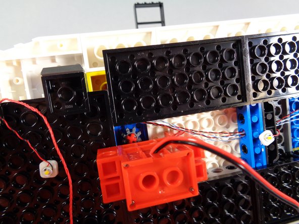 As shown in the first photo for this step, attach the roof motor so its gear meshes with the gear of the roof radar.