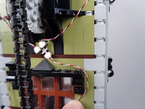As shown in the photos for this step, begin routing the light strip wire using the same approach you used for the magnetic switch wire, except on the right side of the window frames this time.