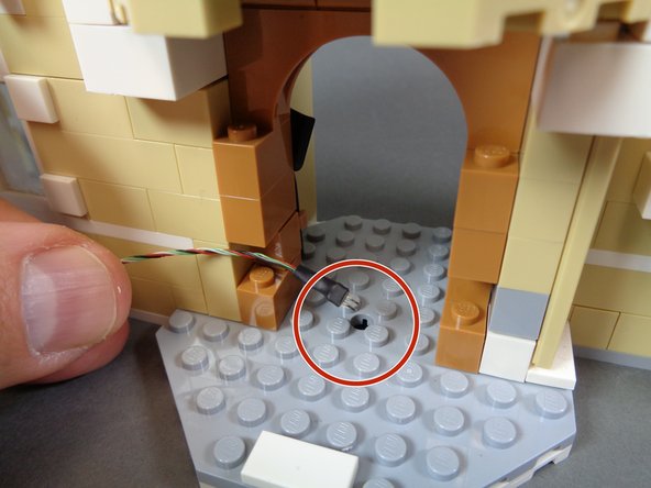 Now you will pass the black end of the connecting cable through the hole in the kitchen floor, as shown by the red circle in the first photo.