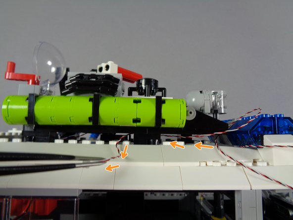 The second photo for this step shows the front lightbar attached, with its control wire passing to the side.