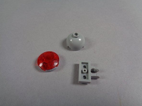 As shown in the photos for this step, remove the large red roof beacon, leaving its black clip still attached to the roof of your Ecto-1.