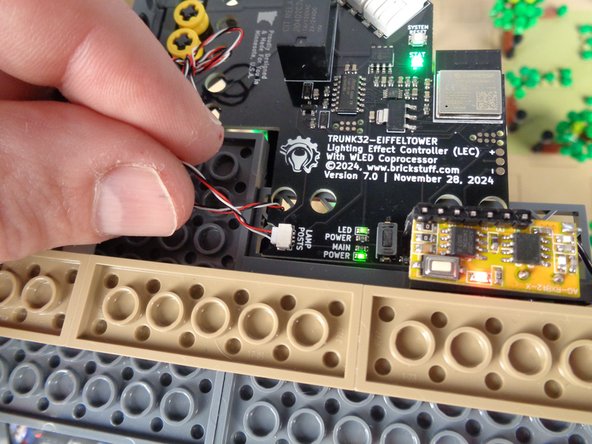 As shown in the third photo for this step, re-connect the control cable to the &quot;LAMP POSTS&quot; plug on the main controller.