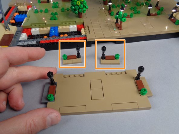 If the two lamp posts shown by the orange boxes in the first photo for this step separated along with Panel 4L, you will need to re-position them onto the large center Panel 4 as shown in the second and third photos.