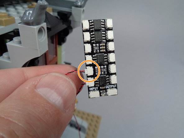 As shown by the orange circle in the second photo for this step, connect the front porch light wire to plug #2 on the BRANCH12X adapter board.