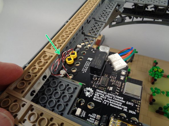 As shown by the green arrow in the third photo, make sure to move all wire to the edge of the main controller.  Keep it away from the row of holes in the main controller board (this is where the middle section of your Eiffel Tower will sit, and this area needs to be clear of wires in order for the middle section to sit flat on top of the base).