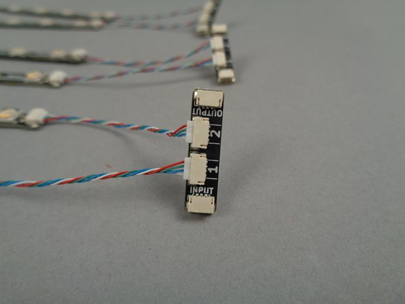 The main controller operates each light strip in a directional chain.  As shown by the orange arrow in the first photo, there is a plug labeled INPUT on each adapter.  This is where the incoming control signal wire will be connected.