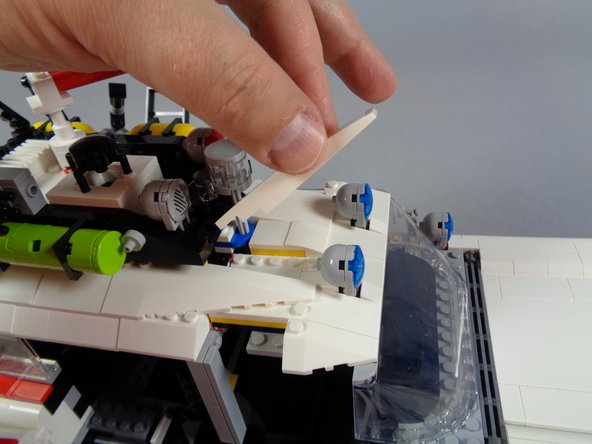 As shown in the second and third photos for this step, you can then re-attach the two long white slopes that connect the front and back roof sections.