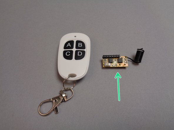 Open the pink bag from Box 1 with the handheld remote control transmitter and receiver.  The green arrow in the first photo for this step shows the receiver board with coiled wire antenna.