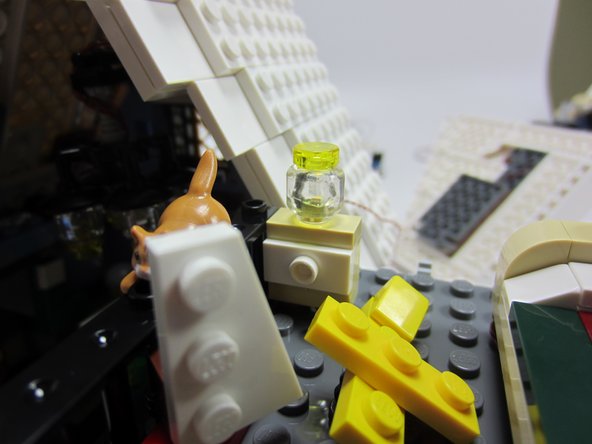 In steps 44 and 45 of the building instructions, build a night light in the bedroom by replacing the two Trans-Clear round 1x1 plates with the Trans-Clear minifig head.  Place a sanded Micro Light Board inside the globe, and route the wire down through the baseplate as shown (down through the kitchen).