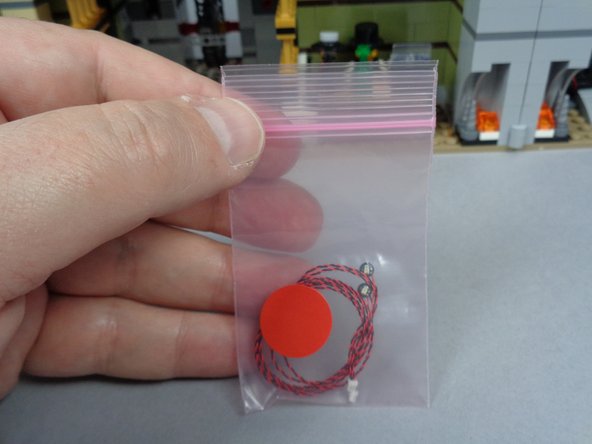 As shown in the first photo for this step, your BOX #2 has a pink bag with a red sticker on it.  Inside this bag are two red Pico LED lights.  You will use both of these for the pharaoh's eyes.