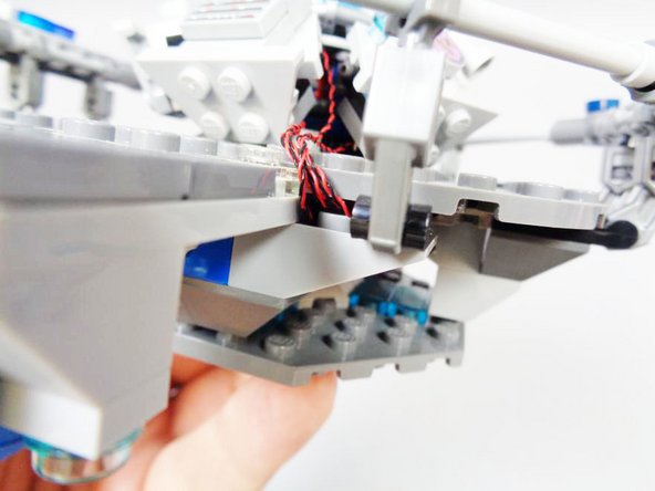 As shown in the second and third photos, you can remove one of the round light blue transparent plates under the console floor to hold the wires in place.