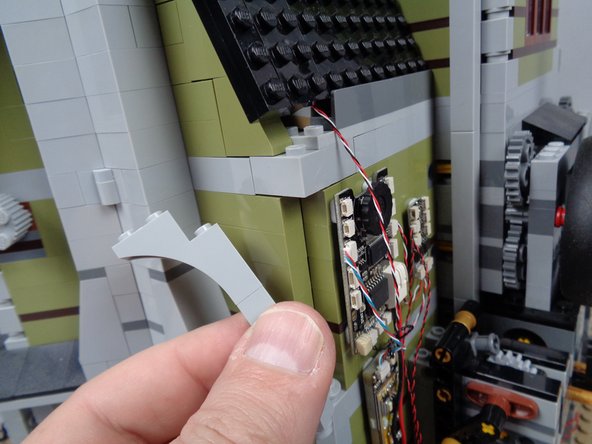 As shown in the first two photos for this step, continue removing parts from the back wall, and use your brick separator to gently pry up the bricks at the back corner.